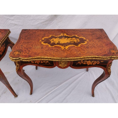 112 - A pair of 20th century walnut and marquetry card tables, the folded tops with eared corners mounted ... 