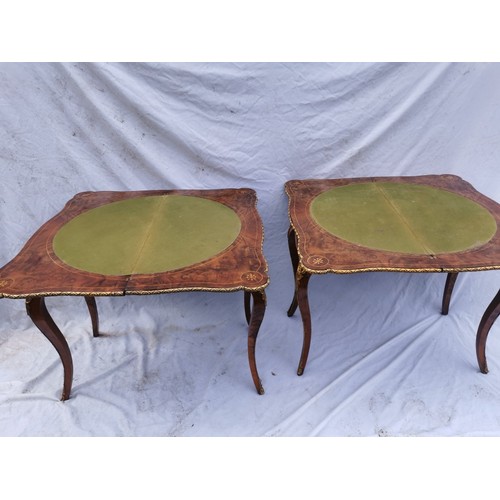 112 - A pair of 20th century walnut and marquetry card tables, the folded tops with eared corners mounted ... 