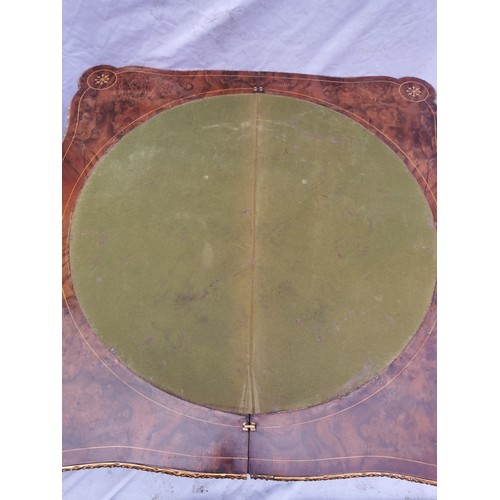 112 - A pair of 20th century walnut and marquetry card tables, the folded tops with eared corners mounted ... 