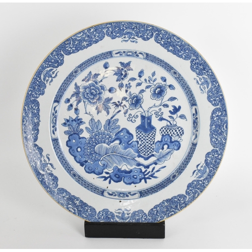 17 - A large Chinese Qing dynasty blue and white porcelain charger, in the Kangxi style with central flor... 