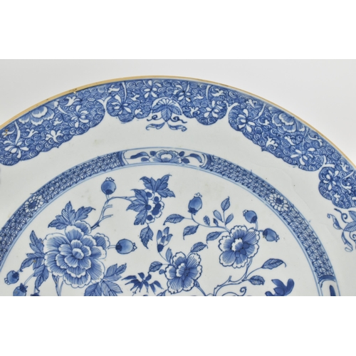 17 - A large Chinese Qing dynasty blue and white porcelain charger, in the Kangxi style with central flor... 