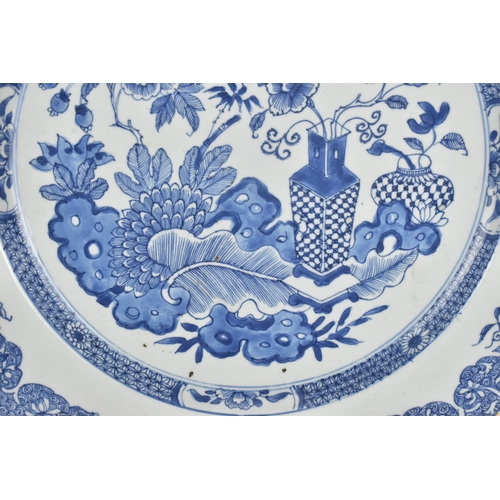 17 - A large Chinese Qing dynasty blue and white porcelain charger, in the Kangxi style with central flor... 