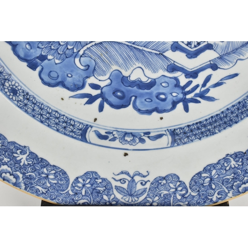 17 - A large Chinese Qing dynasty blue and white porcelain charger, in the Kangxi style with central flor... 