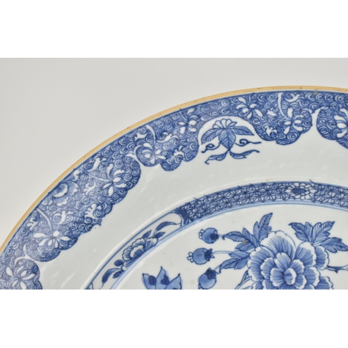 17 - A large Chinese Qing dynasty blue and white porcelain charger, in the Kangxi style with central flor... 