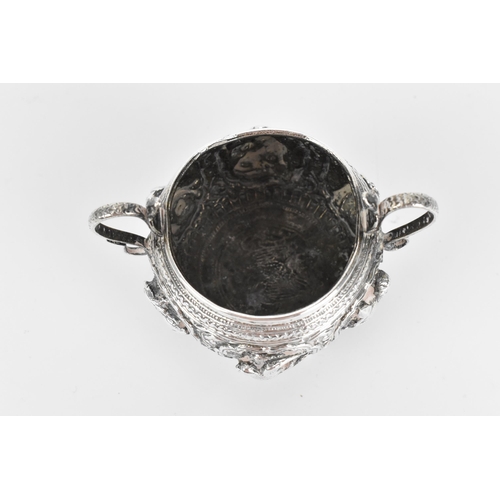 45 - An Indian colonial white metal twin-handled pot, possibly Bombay, circa 1890/1900, with deep embosse... 