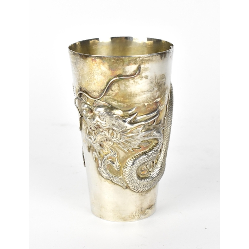 55 - A Chinese export silver tall beaker cup by Wang Hing & Co, circa 1900, of tapered form with relief d... 