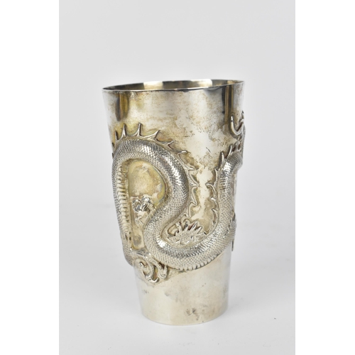 55 - A Chinese export silver tall beaker cup by Wang Hing & Co, circa 1900, of tapered form with relief d... 