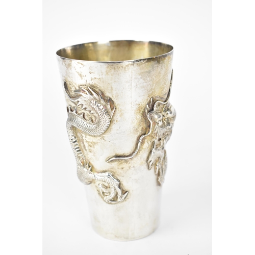 55 - A Chinese export silver tall beaker cup by Wang Hing & Co, circa 1900, of tapered form with relief d... 