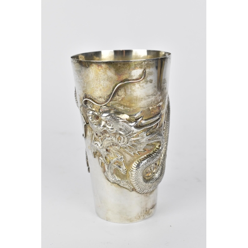 55 - A Chinese export silver tall beaker cup by Wang Hing & Co, circa 1900, of tapered form with relief d... 