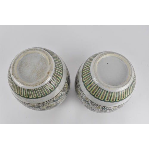 60 - A pair of Chinese Famille Verte ginger jars, decorated in the Kangxi style with leaf tip frieze to t... 