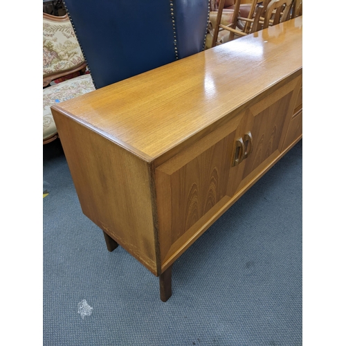 11 - A mid 20th century retro G-Plan teak sideboard having two cupboard doors, three drawers and a pull-d... 