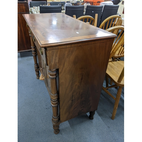 179 - A Regency Chiffonier with two short drawers above fielded, panelled cupboards, flanked by turned col... 