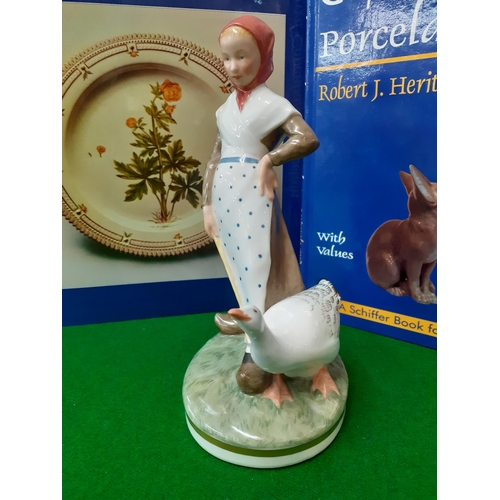 82 - Royal Copenhagen - a young lady wearing a salmon pink headscarf holding a stick with a goose by her ... 