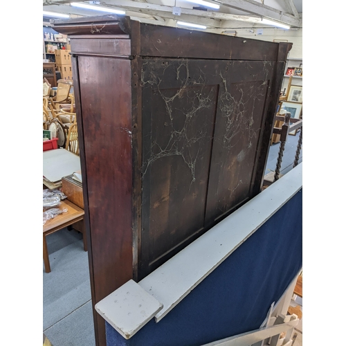 9 - An early 19th century mahogany two door glazed bookcase having a moulded cornice, loose shelves and ... 