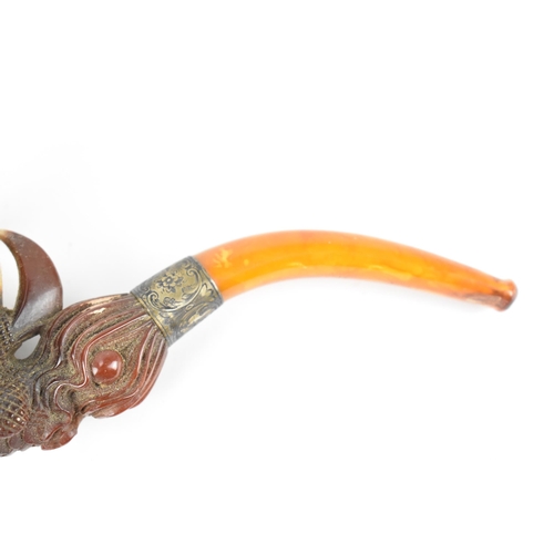 195 - A large Meerschaum pipe carved in the form of a bird’s claw, with silver mounted amber cover and amb... 