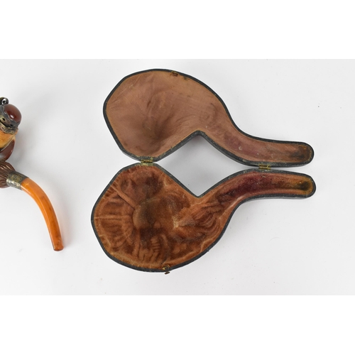 195 - A large Meerschaum pipe carved in the form of a bird’s claw, with silver mounted amber cover and amb... 