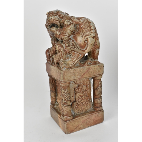 69 - A pair of carved soapstone models of temple guardian Foo dogs, each modelled with a large dog and sm... 