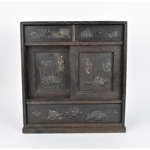 73 - A Japanese Meiji period table top cabinet, late 19th century, in dark oak, with two short drawers ab... 