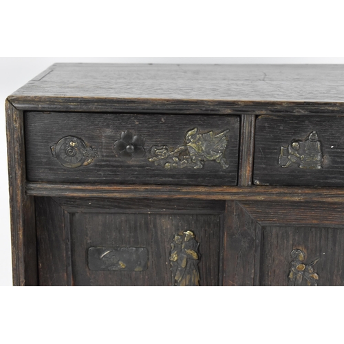 73 - A Japanese Meiji period table top cabinet, late 19th century, in dark oak, with two short drawers ab... 