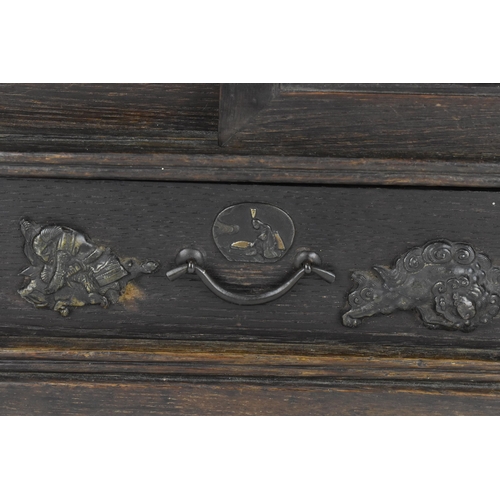 73 - A Japanese Meiji period table top cabinet, late 19th century, in dark oak, with two short drawers ab... 