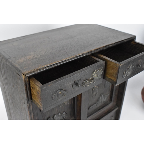 73 - A Japanese Meiji period table top cabinet, late 19th century, in dark oak, with two short drawers ab... 