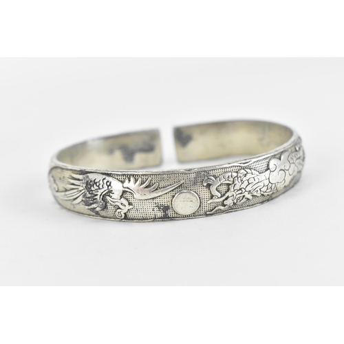 80 - A set of three Chinese white metal torque bangles, with stamped character hallmark, designed with dr... 