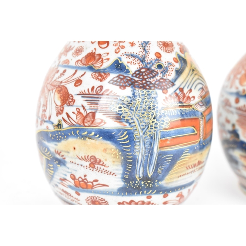 84 - A pair of 19th century Imari porcelain vases, of bottle vase shape with knopped necks, the top appli... 