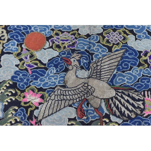 102A - A Chinese Qing dynasty kesi tapestry rank badge, embroidered with mandarin duck facing the sun on a ... 