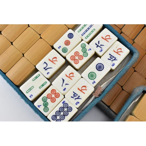 213 - A Chinese leather cased Mahjong bone and bamboo set, the case with four pull out fitted trays holdin... 