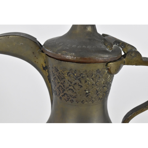 224 - A Middle Eastern Dallah coffee pot, with foliate pattern to the top half,27 cm high, together with a... 