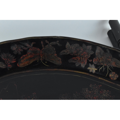 77 - A 19th century Chinese black lacquered tray on stand, the shaped tray with red and faded gilt natura... 