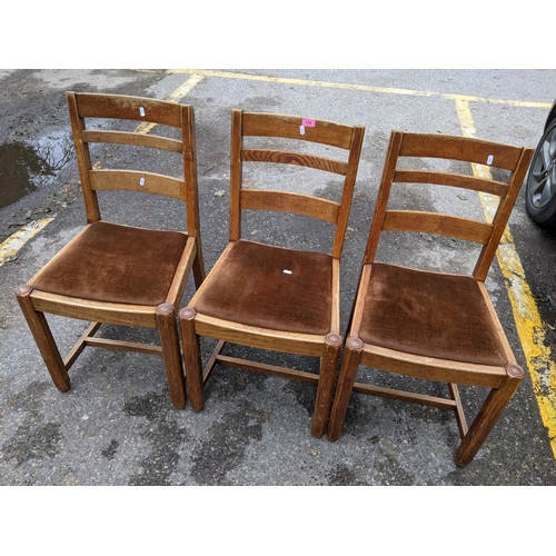 179 - A set of three early 20th century oak ladder back dining chairs on octagonal carved legs and H-stret... 