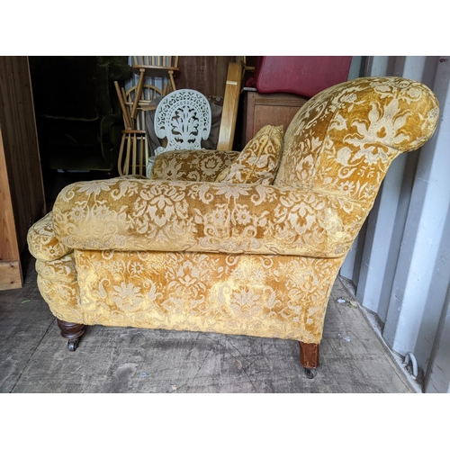 185 - A circa 1900 Howard style low and deep armchair on turned front legs, and on later castors, 83cm h x... 