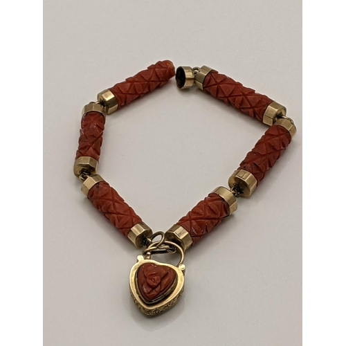 35 - A late 19th/early 20th century yellow metal and carved coral bracelet with heart shaped mourning loc... 