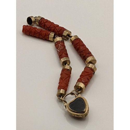 35 - A late 19th/early 20th century yellow metal and carved coral bracelet with heart shaped mourning loc... 