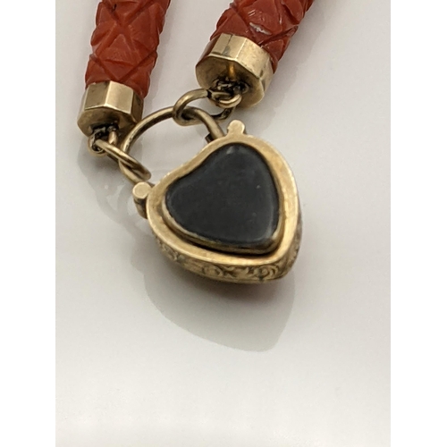 35 - A late 19th/early 20th century yellow metal and carved coral bracelet with heart shaped mourning loc... 