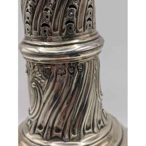 75 - A late Victorian silver sugar caster having embossed reeded body, 'C' scrolls and initials, hallmark... 