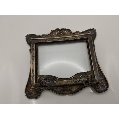 84 - An Art Nouveau sterling silver photograph frame having a floral design, numbered B2829 to the revers... 