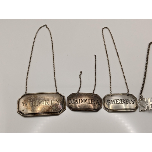 86 - Four early 20th century silver decanter labels to include a sterling silver Sherry and sterling silv... 