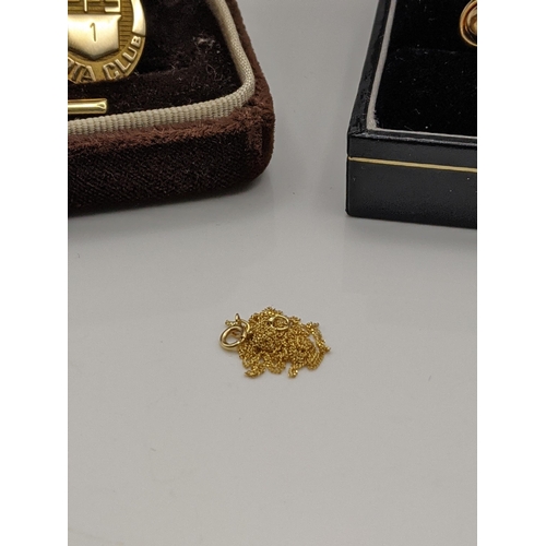 108 - A boxed pair of 18ct gold ear studs 3.1g, together with a 14t gold necklace, 0.6g and a pin badge wi... 