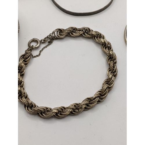 280 - A silver rope style bracelet together with 2 silver napkin rings, a white metal boot pendant togethe... 