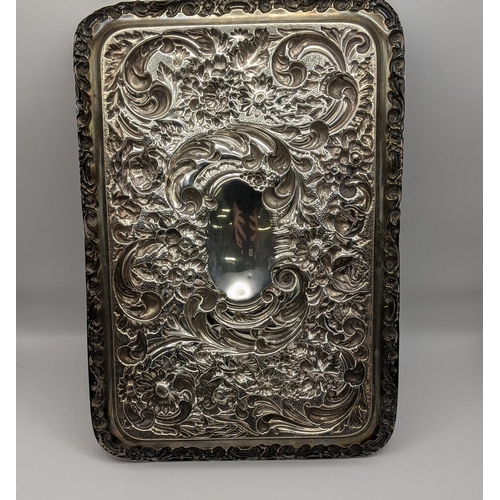 68 - An early 20th century silver embossed rectangular shaped tray decorated with flowers and C-scrolls, ... 