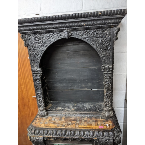 152 - A 19th century ebonized and parquetry carved wooden side cabinet, carved pediment over an arched ope... 