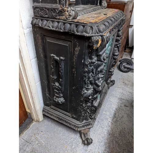 152 - A 19th century ebonized and parquetry carved wooden side cabinet, carved pediment over an arched ope... 