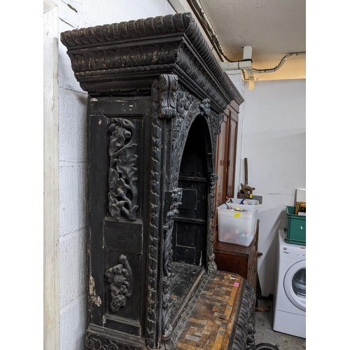 152 - A 19th century ebonized and parquetry carved wooden side cabinet, carved pediment over an arched ope... 