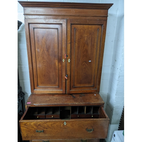 153 - A Georgian mahogany secretaire cabinet, the top with stepped cornice, twin fielded doors and three a... 