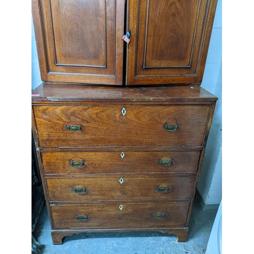 153 - A Georgian mahogany secretaire cabinet, the top with stepped cornice, twin fielded doors and three a... 