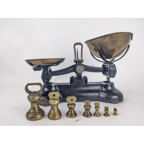 69 - Libra Scale Co black painted cast iron scales with brass pans, and a graduated set of seven bell sha... 