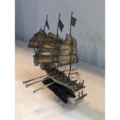 20 - A vintage white metal Chinse style sailboat having three masts and six oars, on treen base
Location:... 