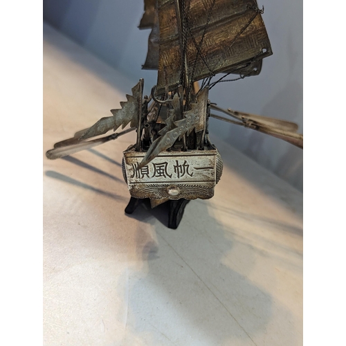 20 - A vintage white metal Chinse style sailboat having three masts and six oars, on treen base
Location:... 